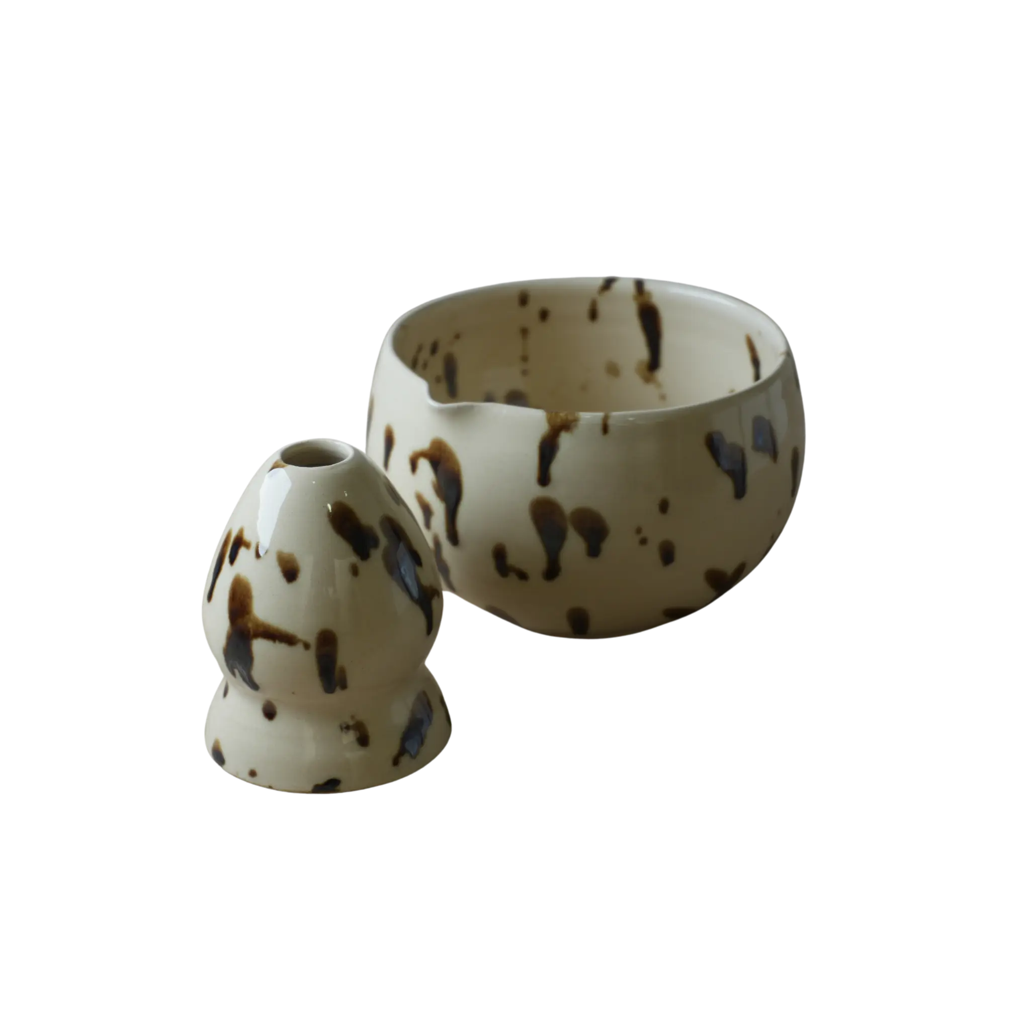 Set cerámica Ushi de taza y soporte con diseño salpicado en tonos beige y marrón sobre fondo negro
