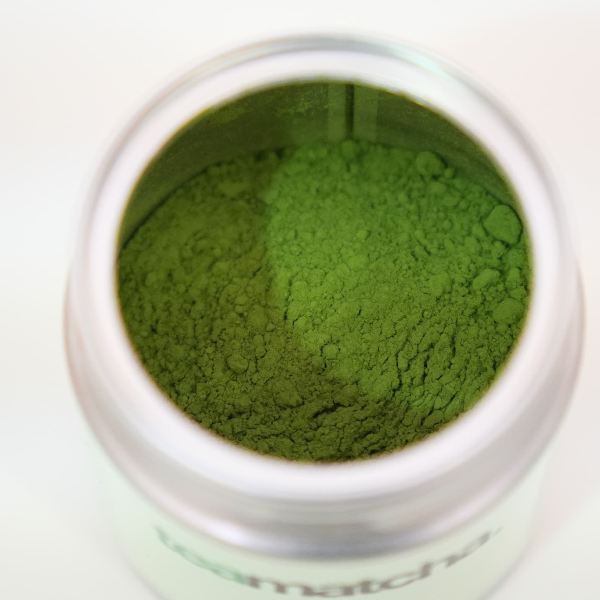 Té matcha premium en polvo verde intenso en envase de metal de teamatcha