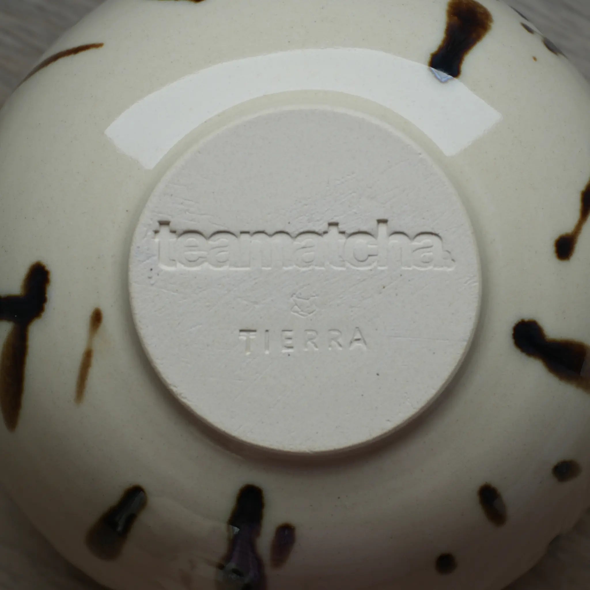 Base de chawan teamatcha con diseño de esmalte blanco y marrón y logo en relieve